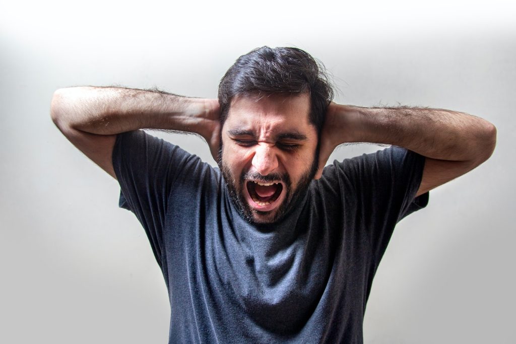 Anxious guy covering his ears